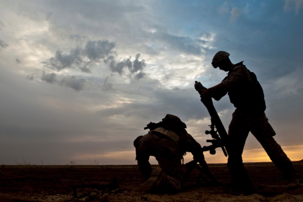 A Coalition member hangs an 81-millimeter mortar prior to launching it at a known ISIS location near the Iraqi-Syrian border, May 13, 2018.