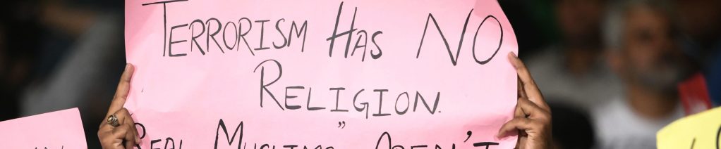 A cricket supporter holds a sign reading "Terrorism has no religion real Muslims aren't terrorists!", after the mass shooting that occurred in New Zealand, during the 2nd elimination PSL Twenty20 match between Peshawar Zalmi and Islamabad United in Karachi on March 15, 2019.