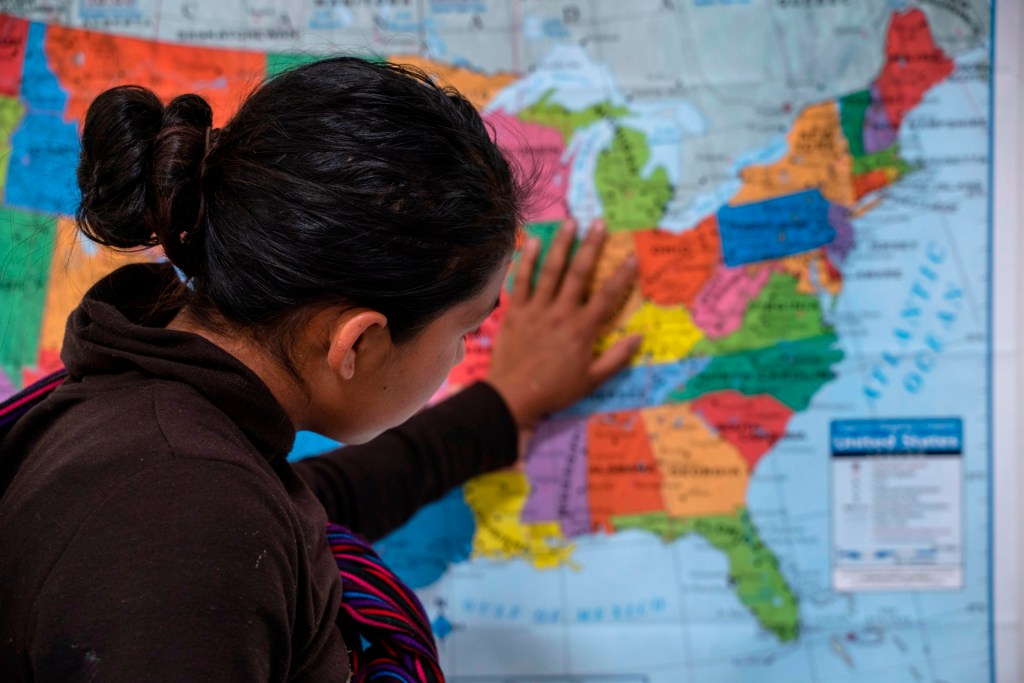 A Guatemalan woman touches a map of the United States