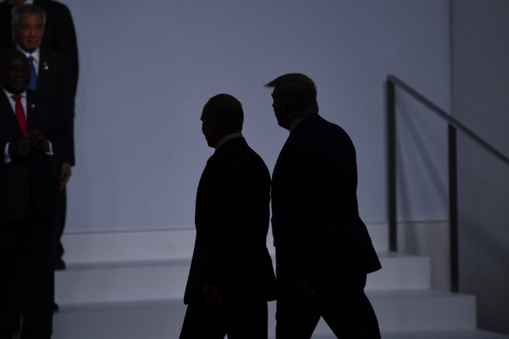 US President Donald Trump (R) walks with Russia's President Vladimir Putin (L)