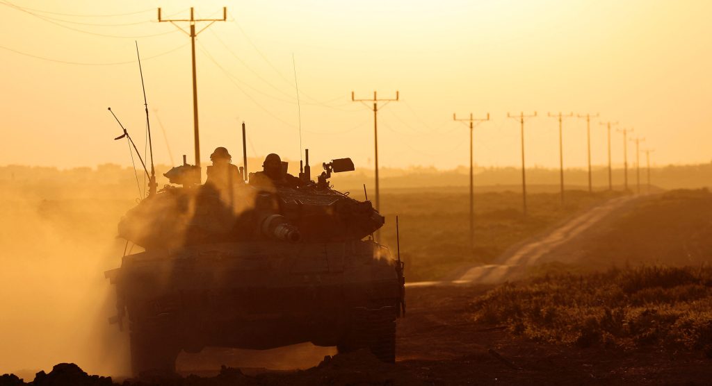 A picture taken from Israel near the border with the Gaza Strip on March 6, 2024 shows an Israeli army tank moving along the border area
