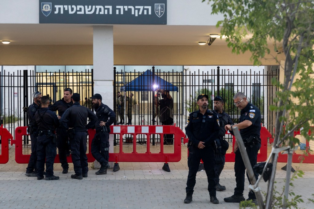 Police officers guard as a worker welds a gate to a military court during a demonstration against Israeli military prosecutors on July 30, 2024 in Kfar Yona, Israel. Yesterday, far-right protesters broke into the Sde Teiman compound to show support for Israeli reservists detained over allegations of abusing a Palestinian detainee. (Photo by Amir Levy/Getty Images)