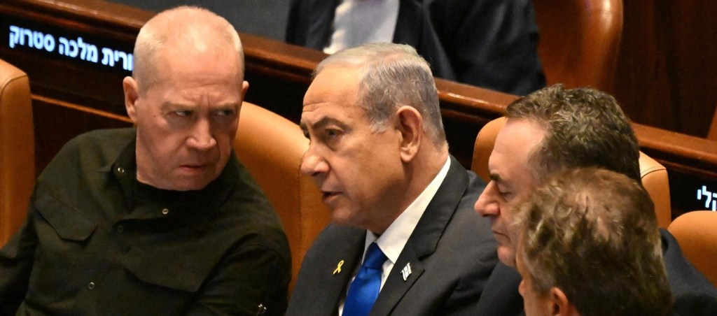 Israeli Prime Minister Benjamin Netanyahu (C) speaks to Defence Minister Yoav Gallant (L) at the opening of the 25th Parliament session in Jerusalem on October 28, 2024.