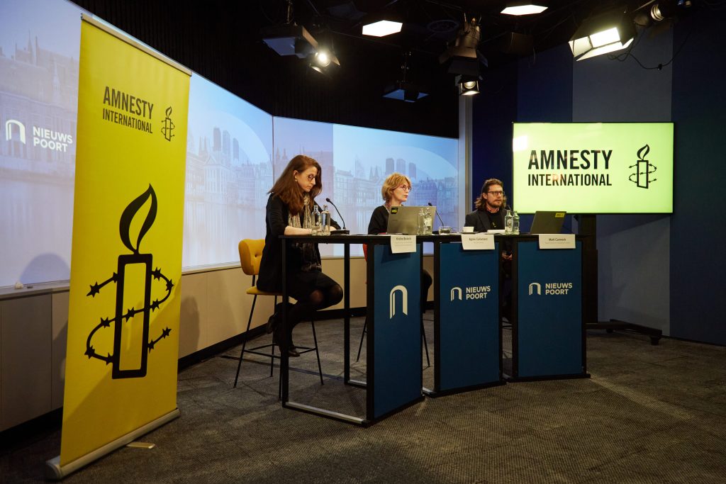 Members of Amnesty International sit for a press conference regarding a report on the conflict in Gaza.
