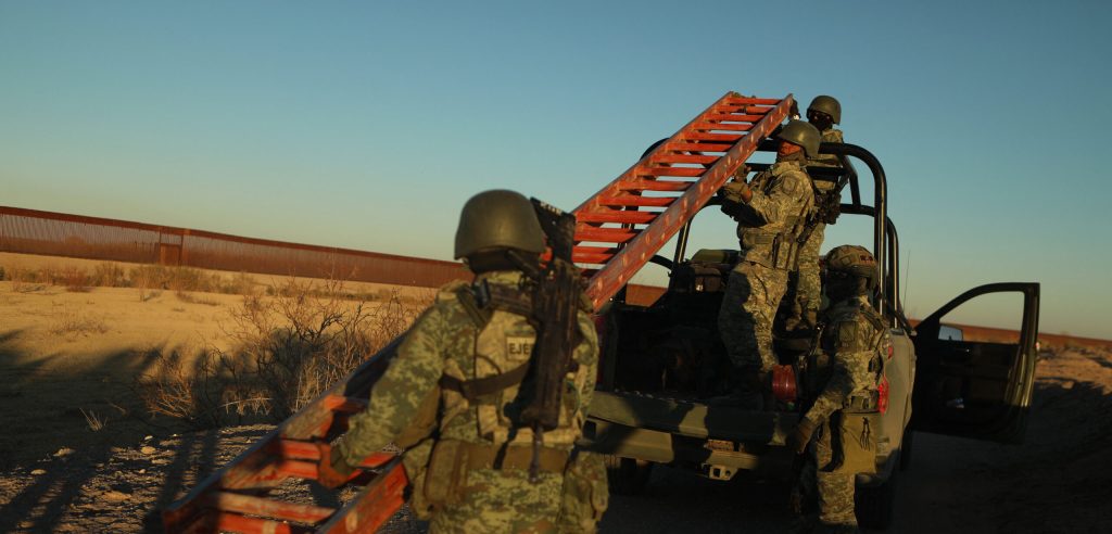 Members of the national guard move a red ladder.