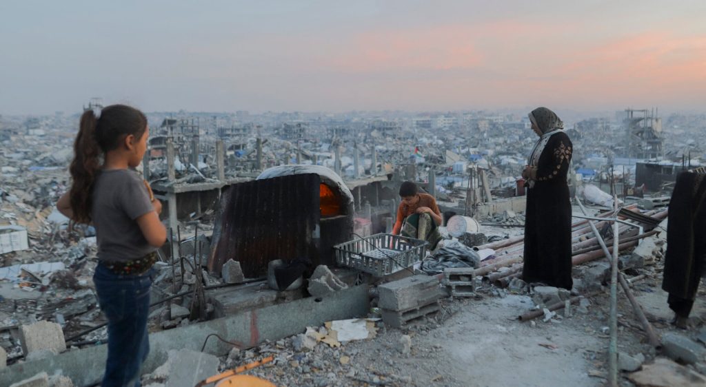 Palestinian kid adds fuel to a fire amidst rubble.