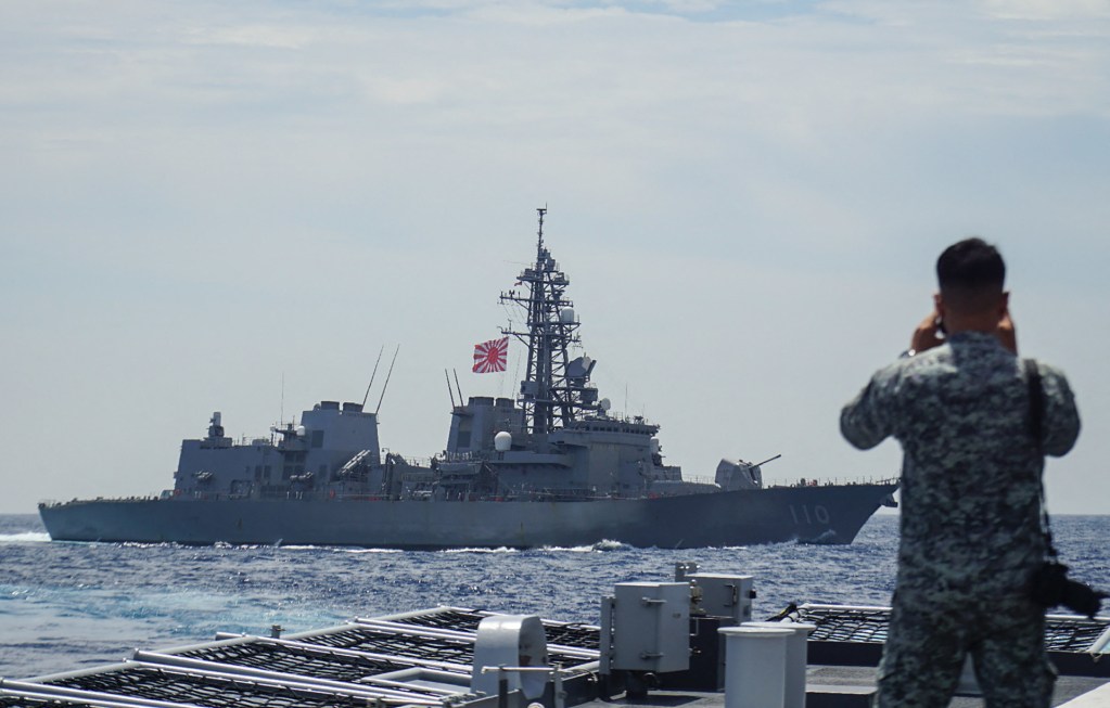 A member of the Philippine Navy looks out at the Japan Maritime Self-Defense Force's destroyer Takanami during a joint maritime exercise in the South China Sea on June 14, 2025. (Photo by STR/JIJI Press/AFP via Getty Images)