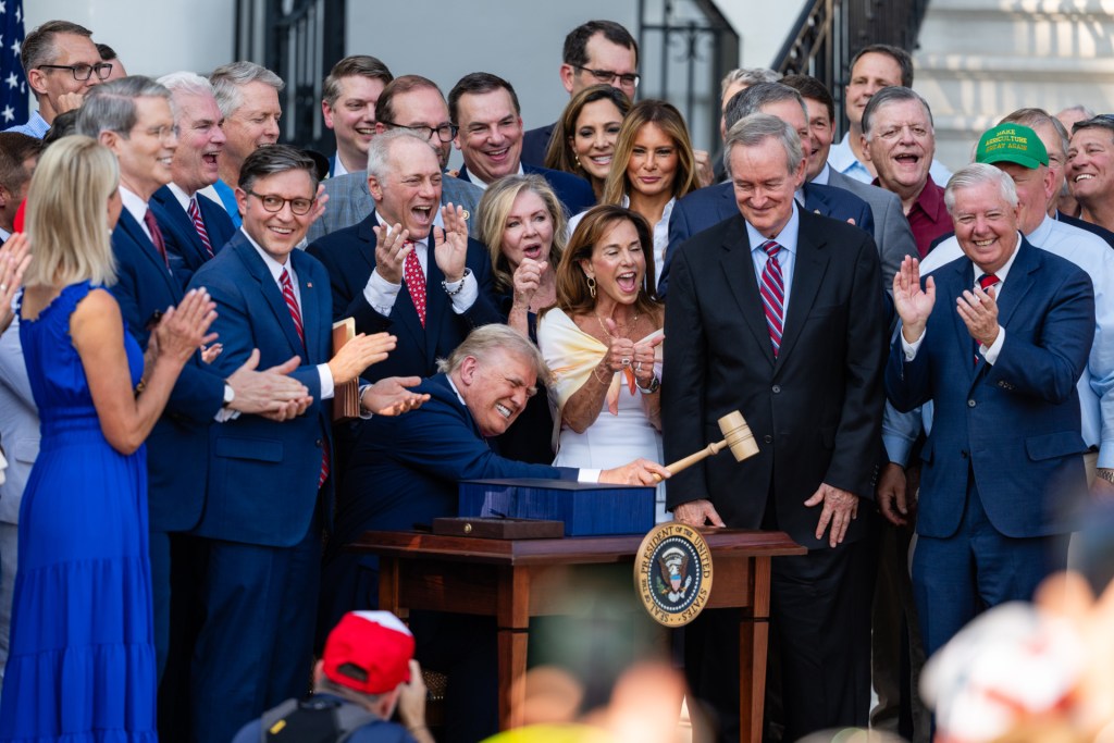 U.S. President Donald Trump, joined by Republican lawmakers, holds a gavel after signing the "One, Big Beautiful Bill" Act into law during an Independence Day military family picnic on the South Lawn of the White House on July 04, 2025 in Washington, DC. (Photo by Eric Lee/Getty Images)