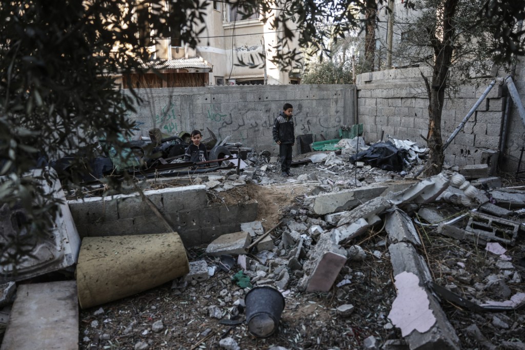 A young boy looks on at the site of an Israeli airstrike in Deir al-Balah on December 9, 2025, which resulted in a Palestinian man being killed.