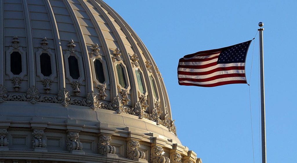 The dome of the U.S. Capitol Buidling and the US flag.